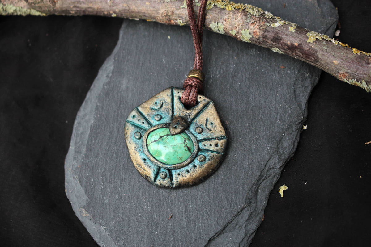 Fantasy artifact pendant featuring intricate details and an antique bronze patina effect