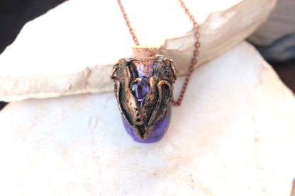 Ancient-inspired fantasy jewelry with bronze ornamentation and a purple vial