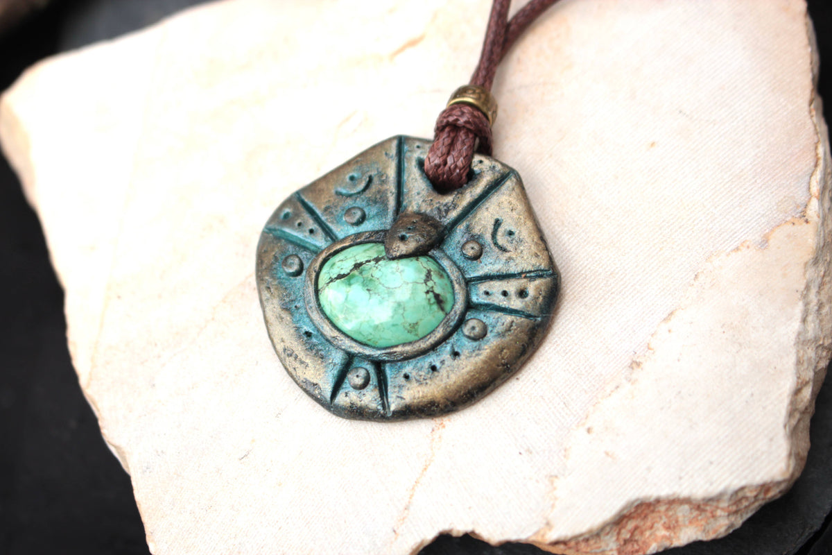 Front view of a handmade ancient relic pendant on a brown waxed cotton cord
