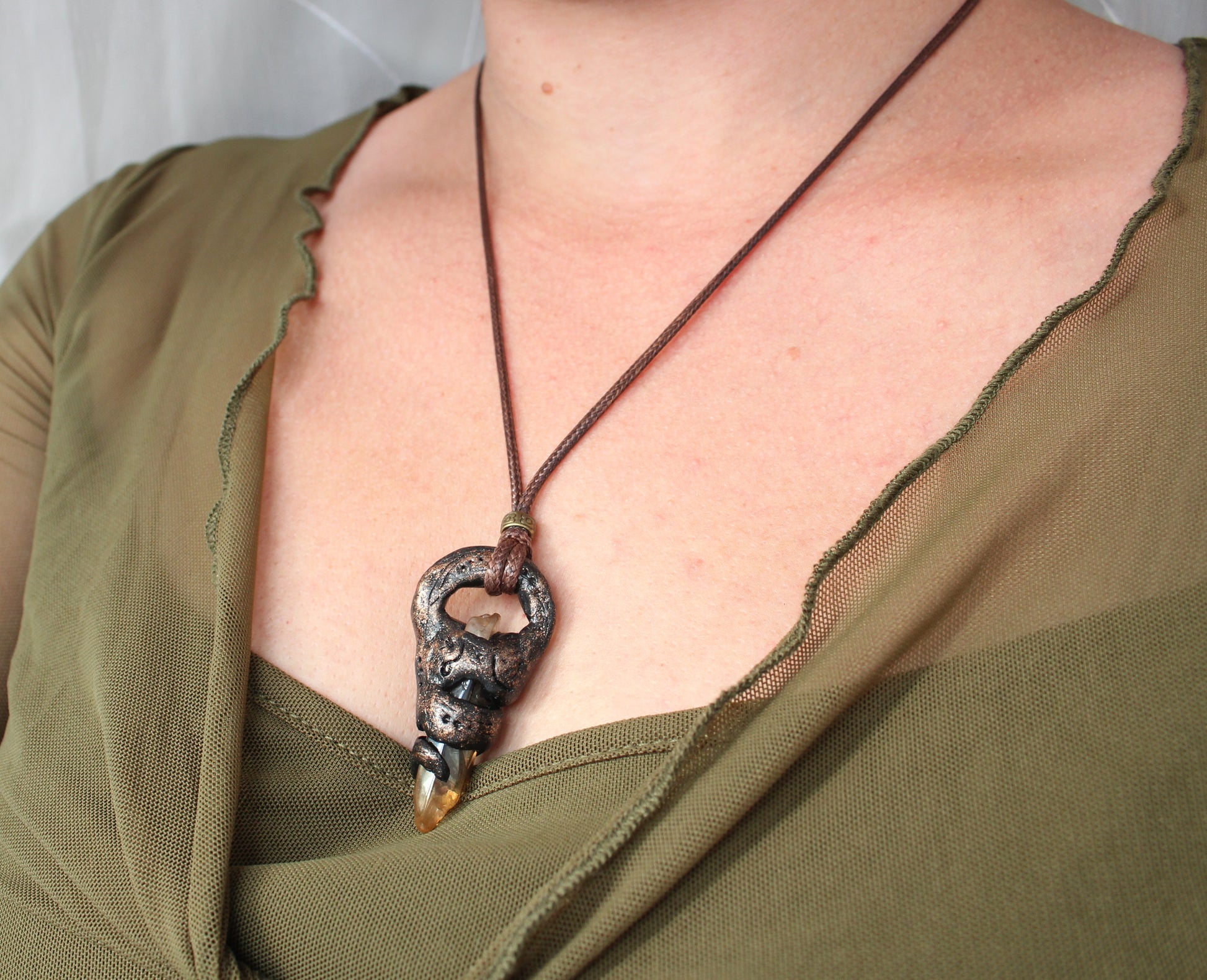 Handmade fantasy relic necklace worn by a model, showing the medieval talisman pendant and adjustable cord style