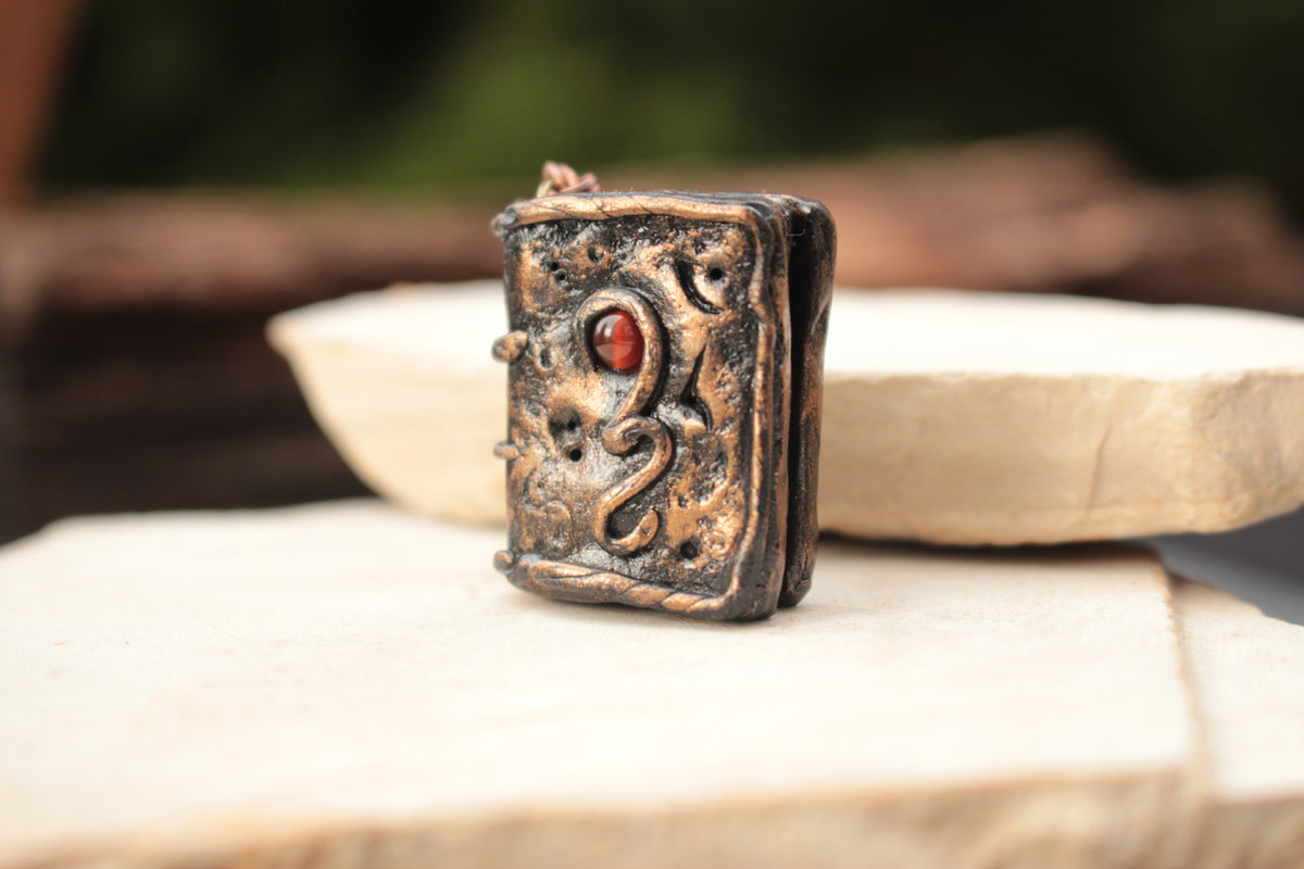 Rustic ancient-style spellbook pendant necklace with metallic finish