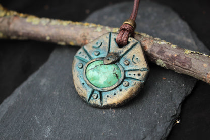 Detailed view of a handmade polymer clay amulet with an aged patina finish