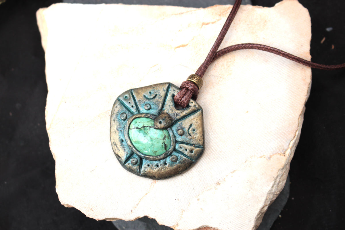 Close-up showing the textured antique patina and intricate details of the fantasy pendant