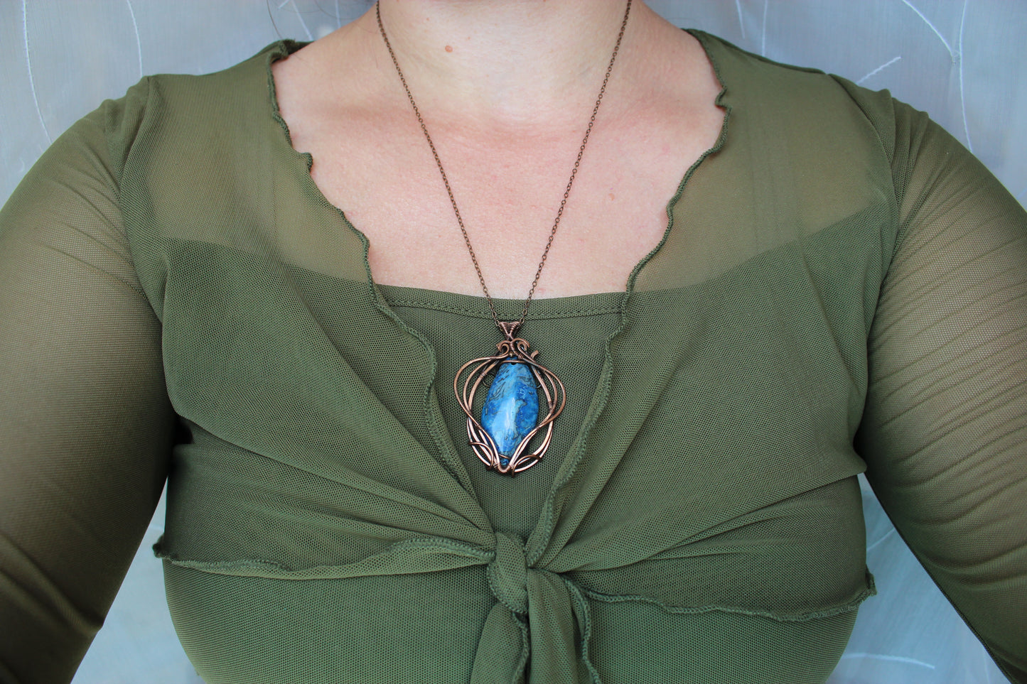 Blue crazy agate gemstone and copper wire wrapping detail in handcrafted pendant