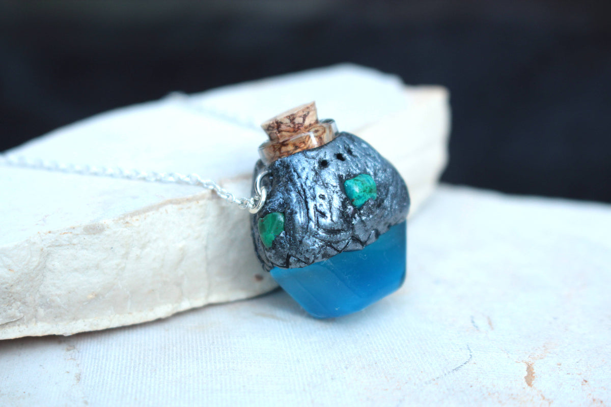 Blue forest-inspired potion jewelry with bronze finish and green accents