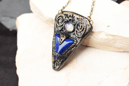 Witchy fantasy necklace with a blue gemstone and rustic bronze details