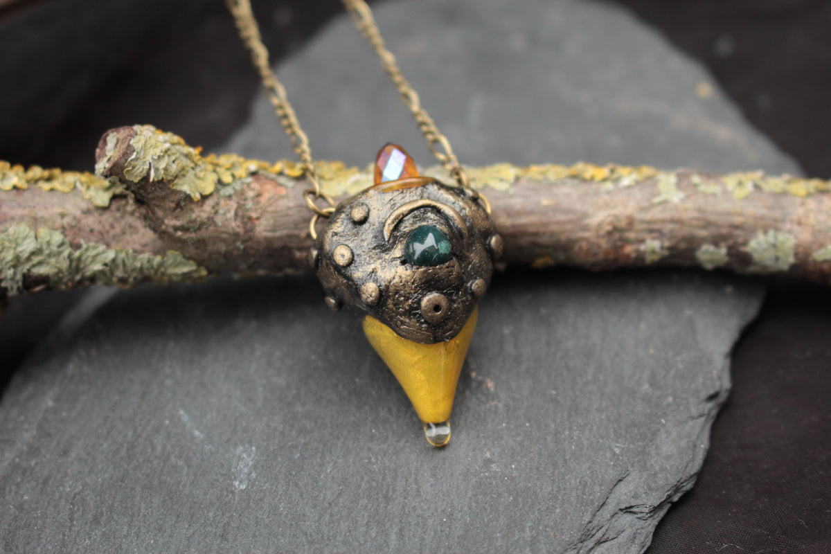 Bronze forest amulet with green gemstone and crystal detail