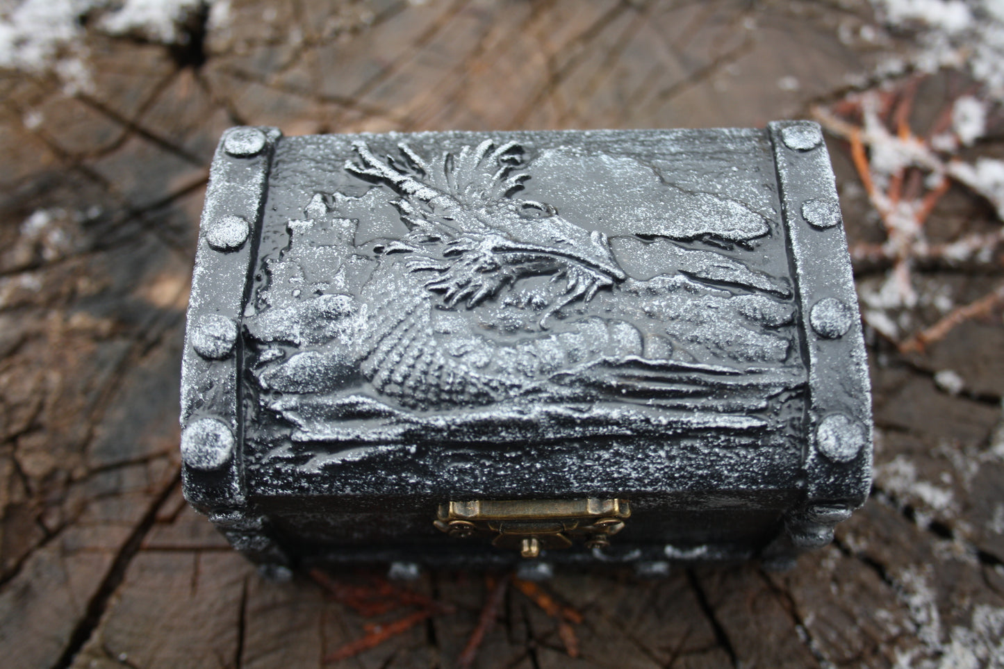 Detailed view of dragon inspired clay decoration on wooden box