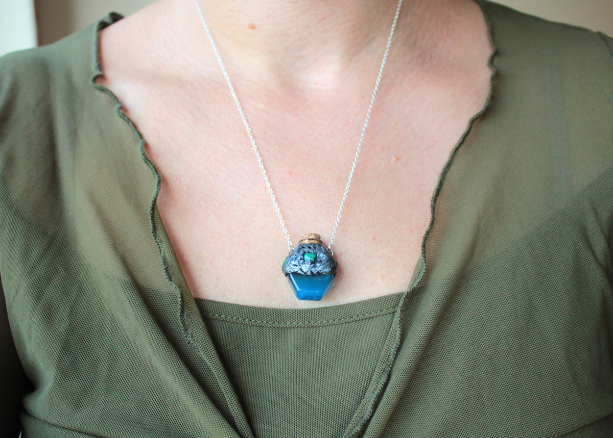 Enchanted blue potion pendant with forest-inspired handmade details