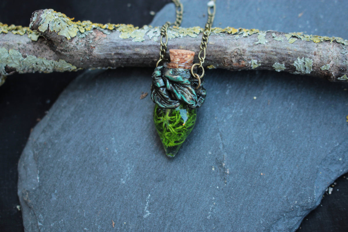 Fantasy pendant featuring preserved-style green moss inside a glass vial