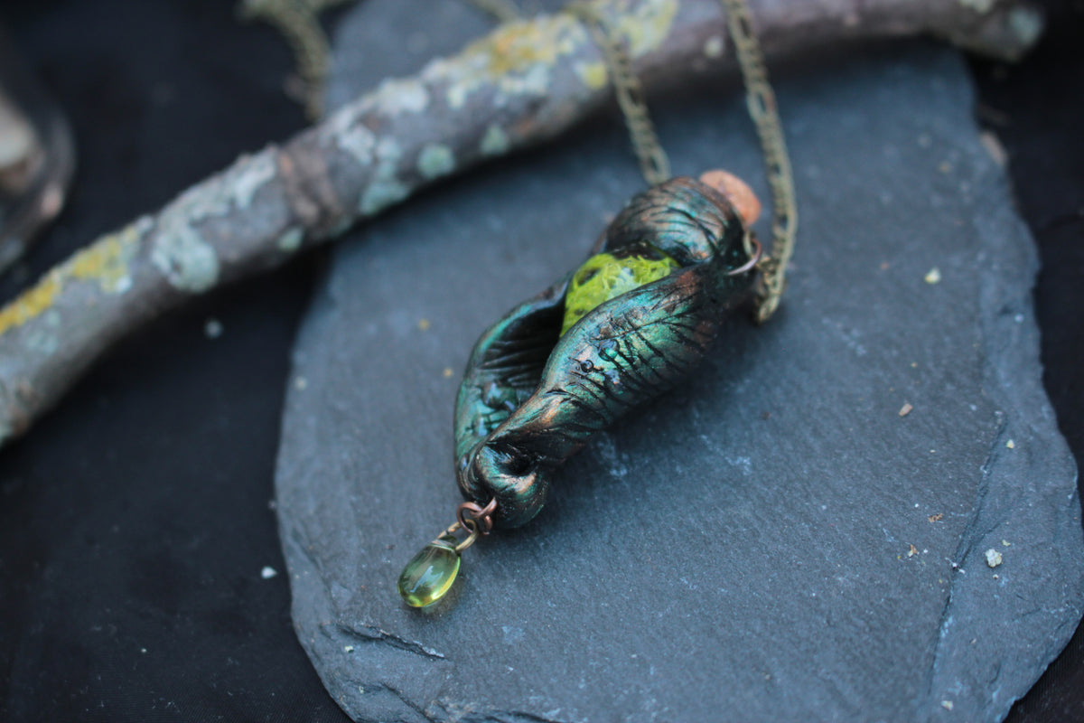Enchanted forest pendant with green, dark botanical details and fantasy design