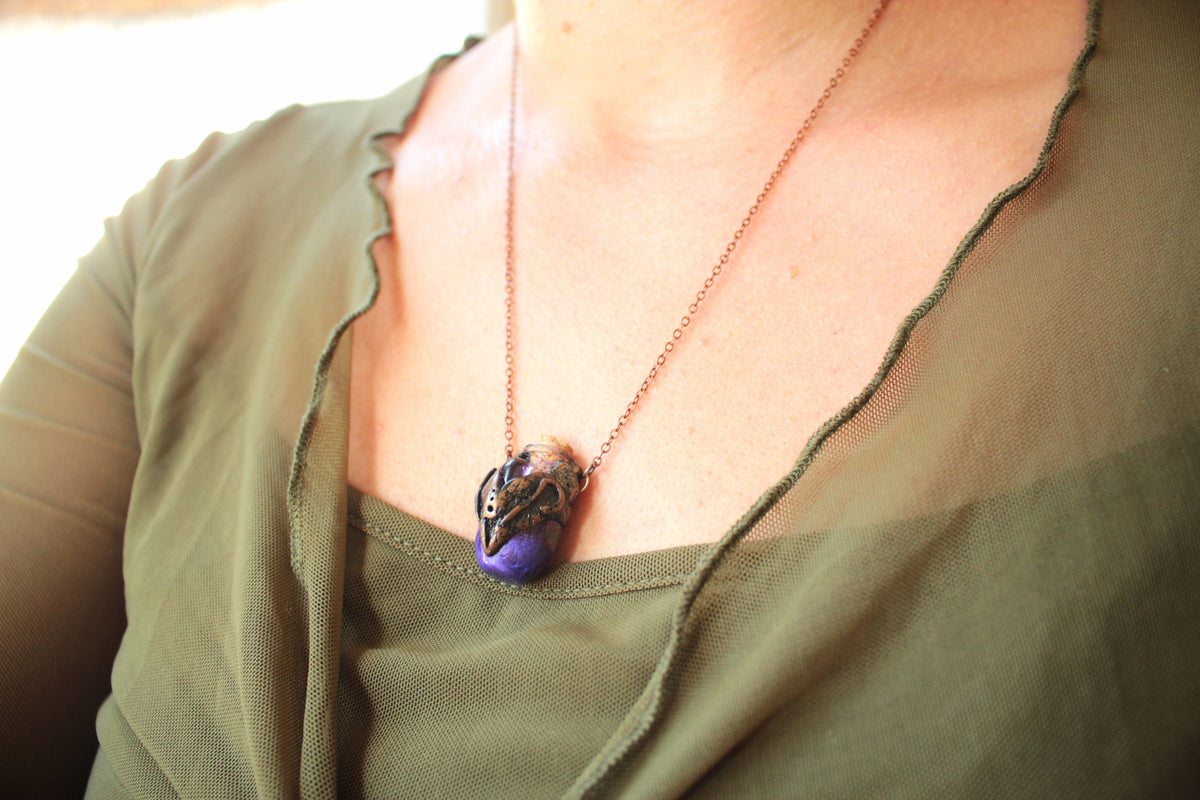 Enchanted purple relic pendant with decorative bronze metalwork and glass