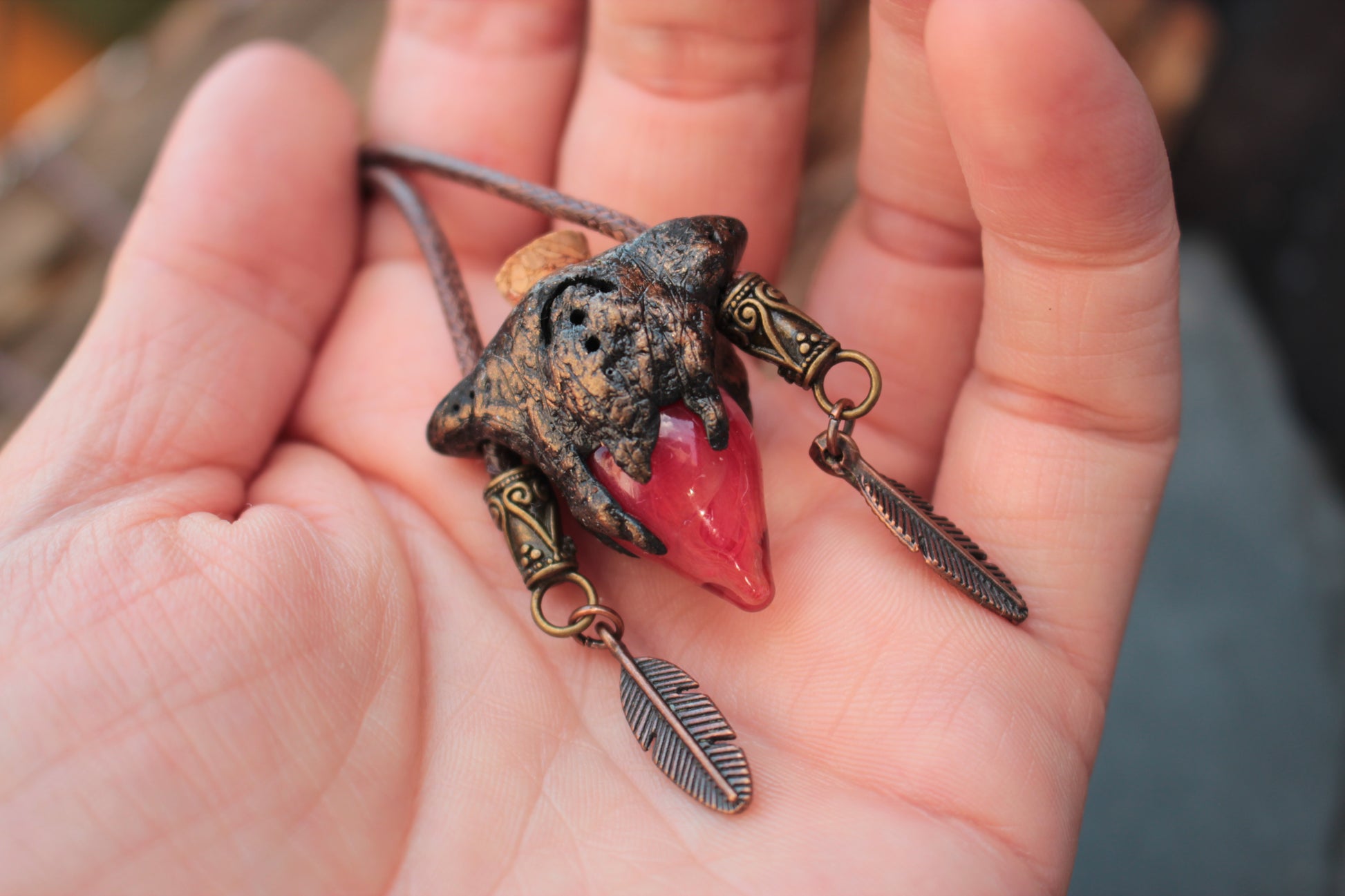 Close up view of a magical red potion relic necklace with bronze details