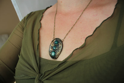 Ancient style pendant with mystical runes and natural green gemstone accents