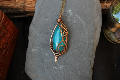 Blue agate gemstone pendant handcrafted with intricate copper wire wrapping