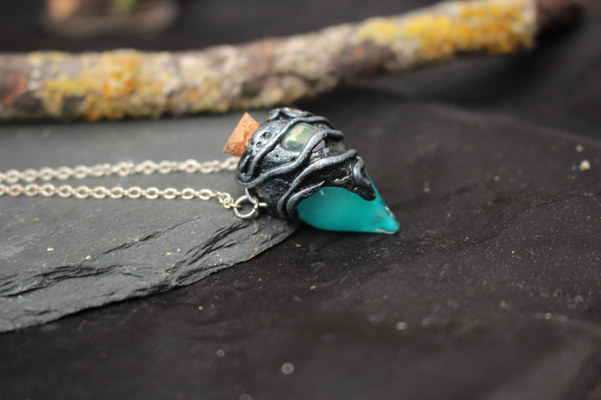Handmade fantasy jewelry featuring a turquoise glowing potion bottle