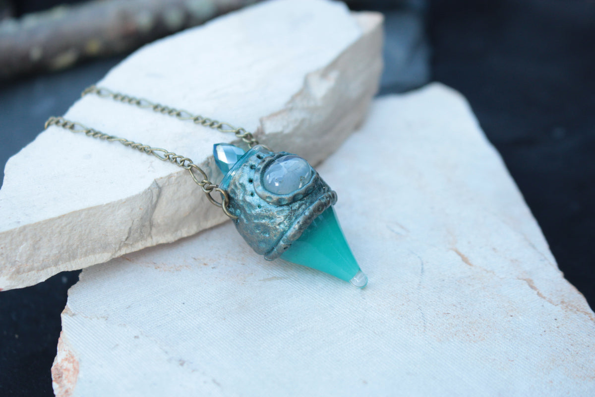 Fantasy necklace for women featuring a glowing turquoise potion bottle
