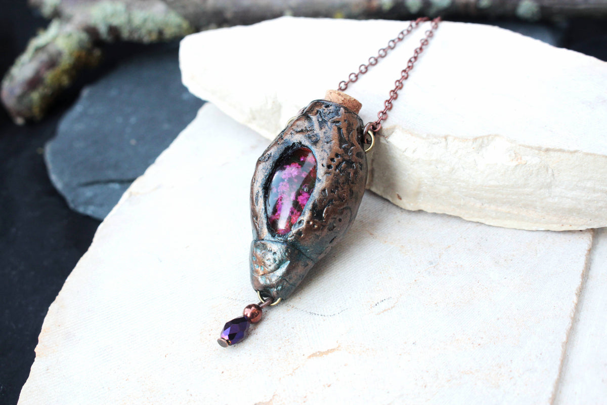 Handmade fantasy necklace displayed against a natural background