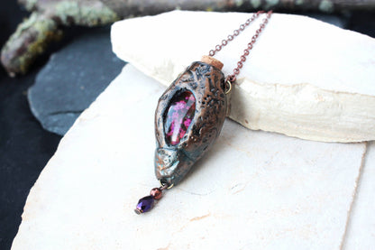 Handmade fantasy necklace displayed against a natural background