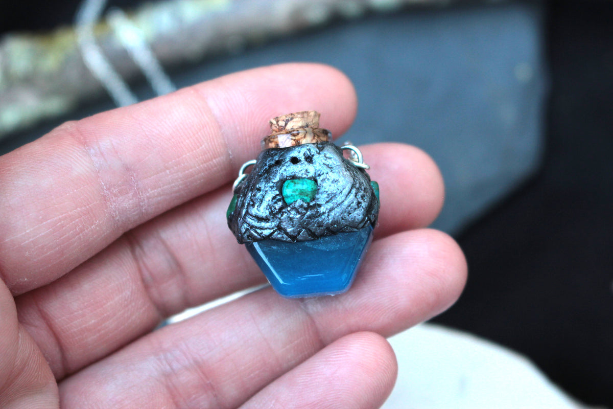 Handmade fantasy potion bottle pendant with blue glowing resin