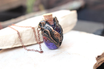 Fantasy relic necklace with an aged bronze appearance and violet potion vial
