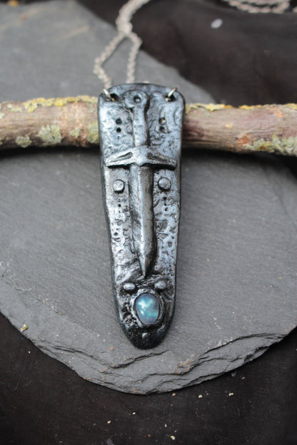 Close-up of a handmade polymer clay sword necklace