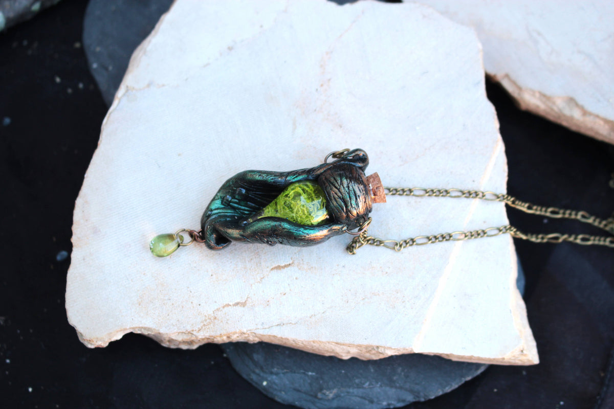 Forest magic necklace with an enchanted green vial and dark leaf inspired pendant