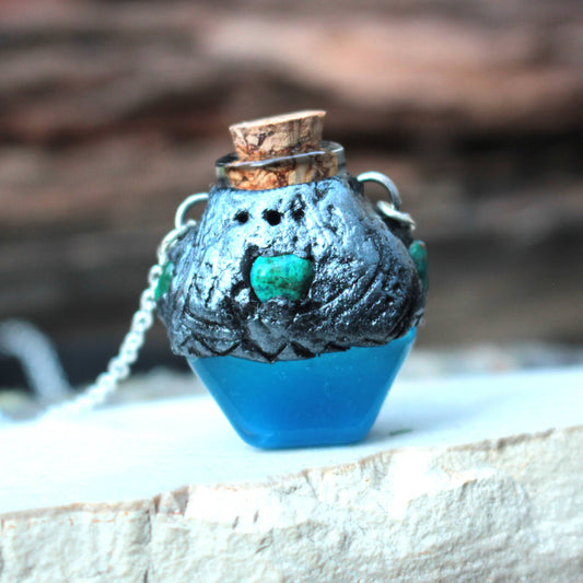 Blue glowing potion necklace with forest-inspired bronze details