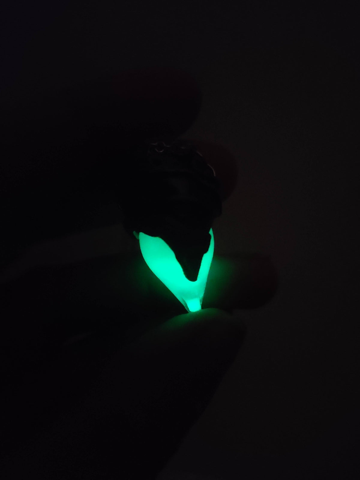 Turquoise potion bottle necklace glowing bright green in the dark