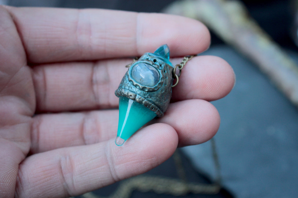 Glowing turquoise pendant necklace with an antique bronze finish