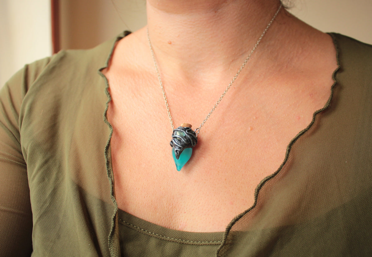Handmade glowing vial pendant with turquoise color and gemstone detail