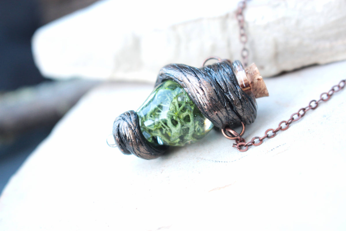 Handmade green vial necklace with rustic woodland-inspired details