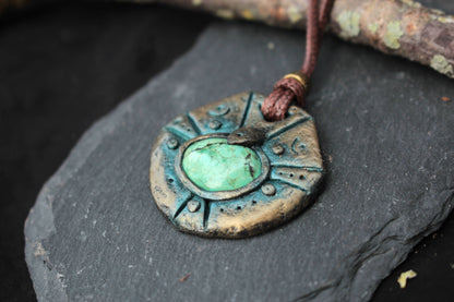 Green gemstone centerpiece set into a handmade antique-style fantasy pendant