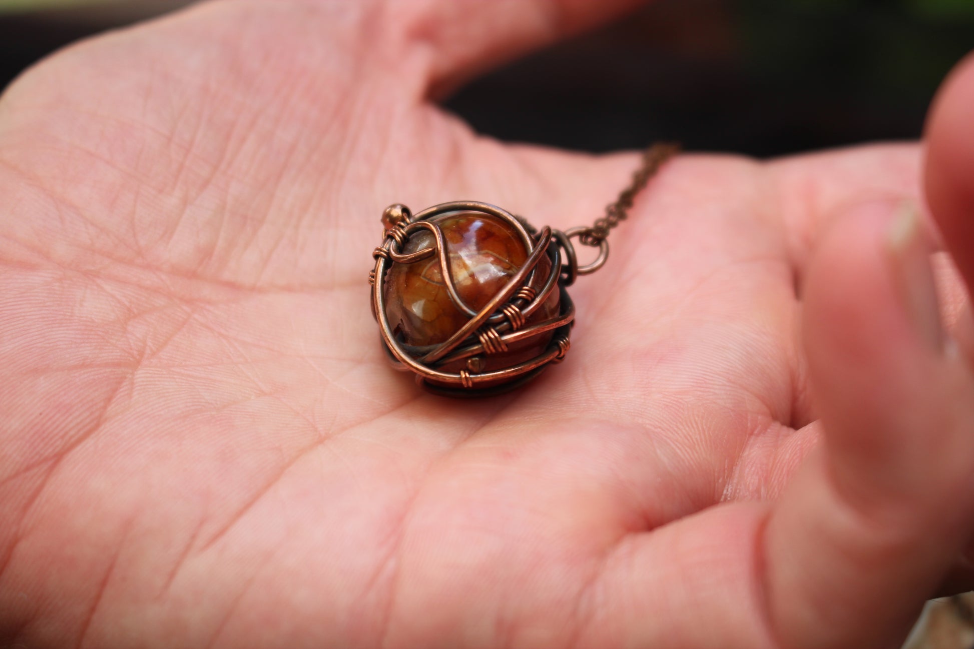 Handcrafted dragon vein agate pendant necklace featuring intricate copper wire wrapping
