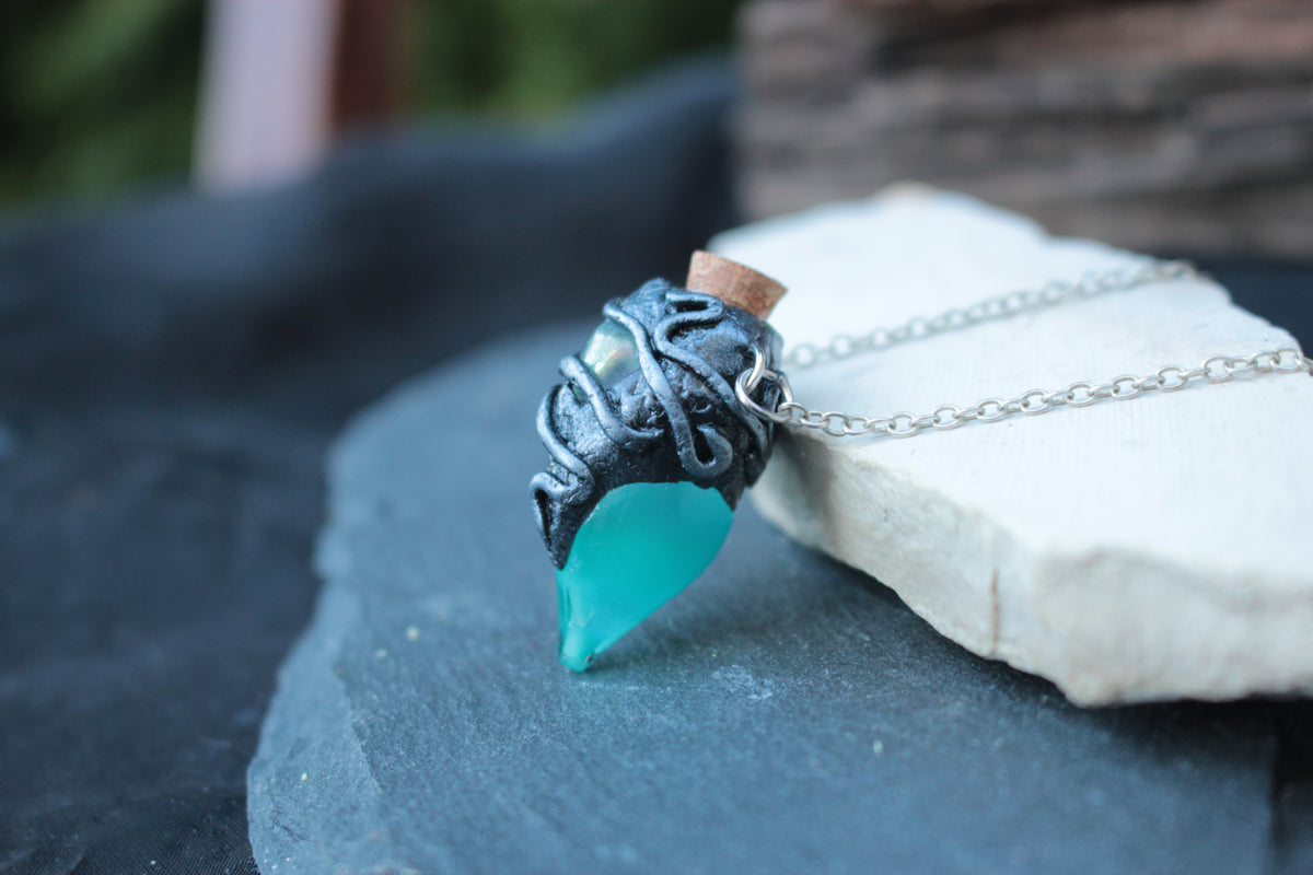 Close-up of handmade polymer clay details on a fantasy potion pendant