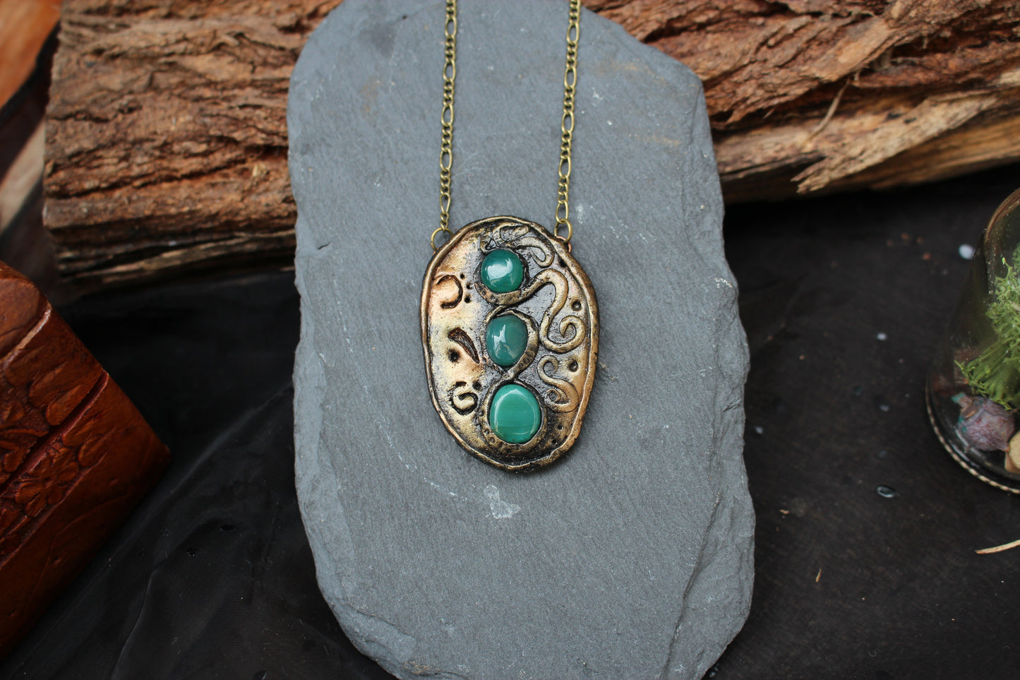 Close view of a handmade fantasy necklace featuring green agate cabochons