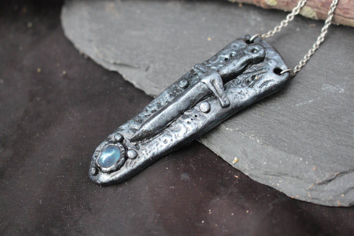 Detailed handmade sword pendant with a mystical gemstone