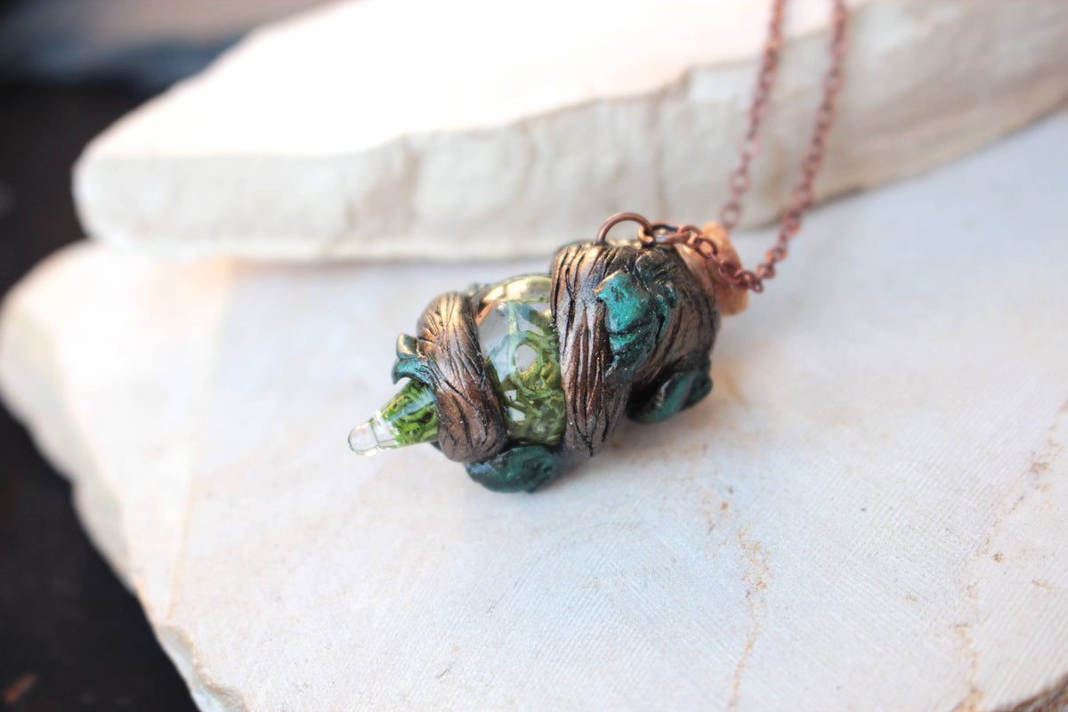 Handmade fantasy jewelry featuring a tiny decorative potion bottle and woodland details