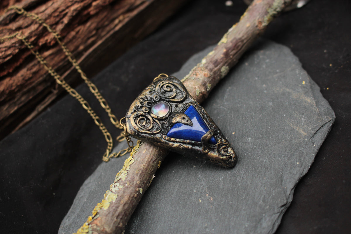 Handmade fantasy talisman jewelry with a deep blue gemstone
