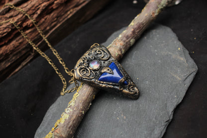 Handmade fantasy talisman jewelry with a deep blue gemstone