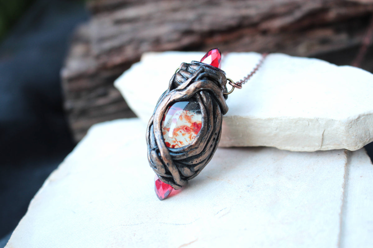 Handmade magical pendant featuring red crystals and a mystical fantasy design