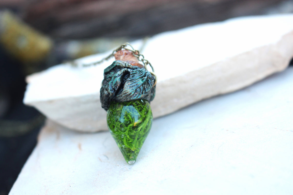 Magical forest-inspired jewelry with a glowing green moss-filled vial