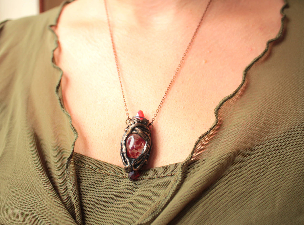 Handmade fantasy pendant with three red crystals, including a broken crystal held securely between the other two