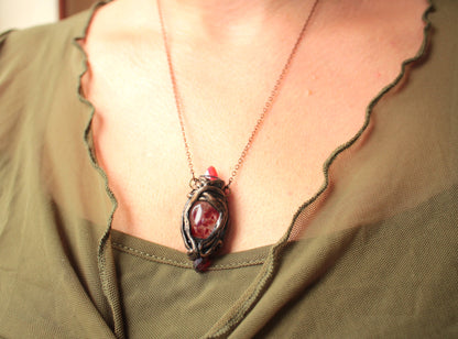 Handmade fantasy pendant with three red crystals, including a broken crystal held securely between the other two