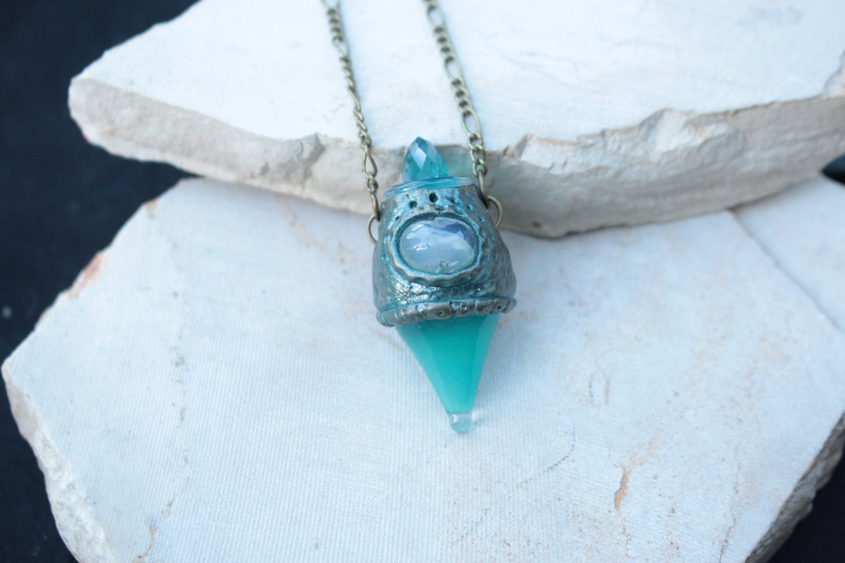 Magical turquoise necklace with a miniature potion pendant and bronze finish