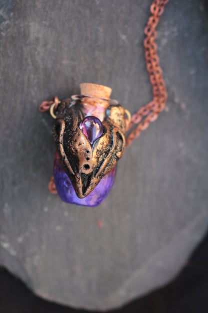 Magical handmade amulet featuring a violet potion bottle suspended from a metal chain