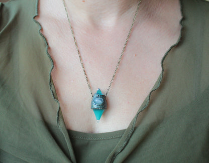 Mystical forest-inspired necklace with a glowing turquoise potion pendant