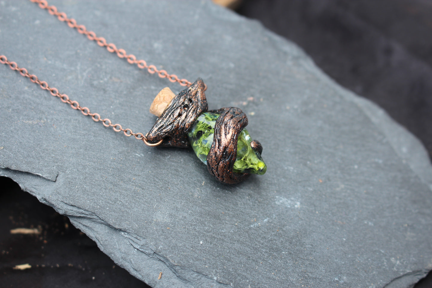 Close-up of the handmade moss potion pendant with sculpted branch details