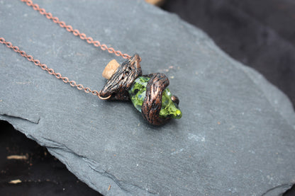 Close-up of the handmade moss potion pendant with sculpted branch details