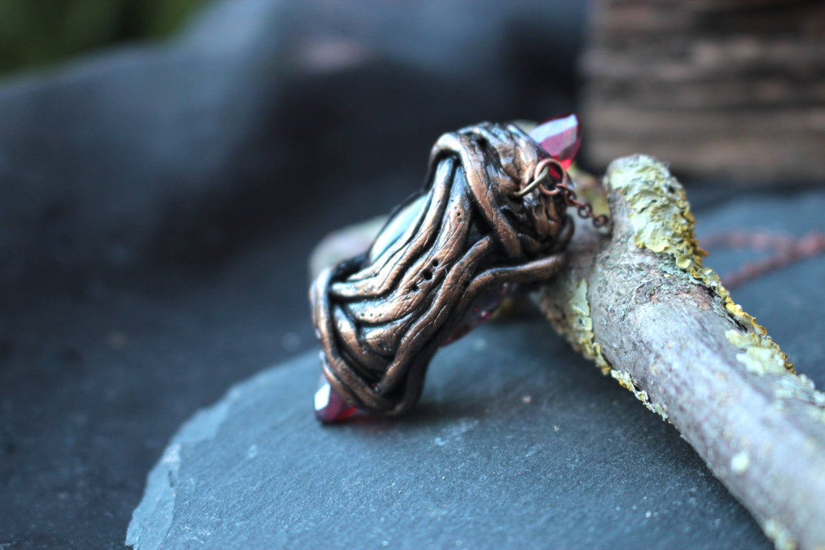 Handmade pendant featuring deep red crystals and a detailed fantasy-inspired design
